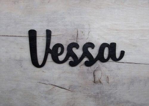 Musta vessa-ovikyltti harmaalla lankkutaustalla.