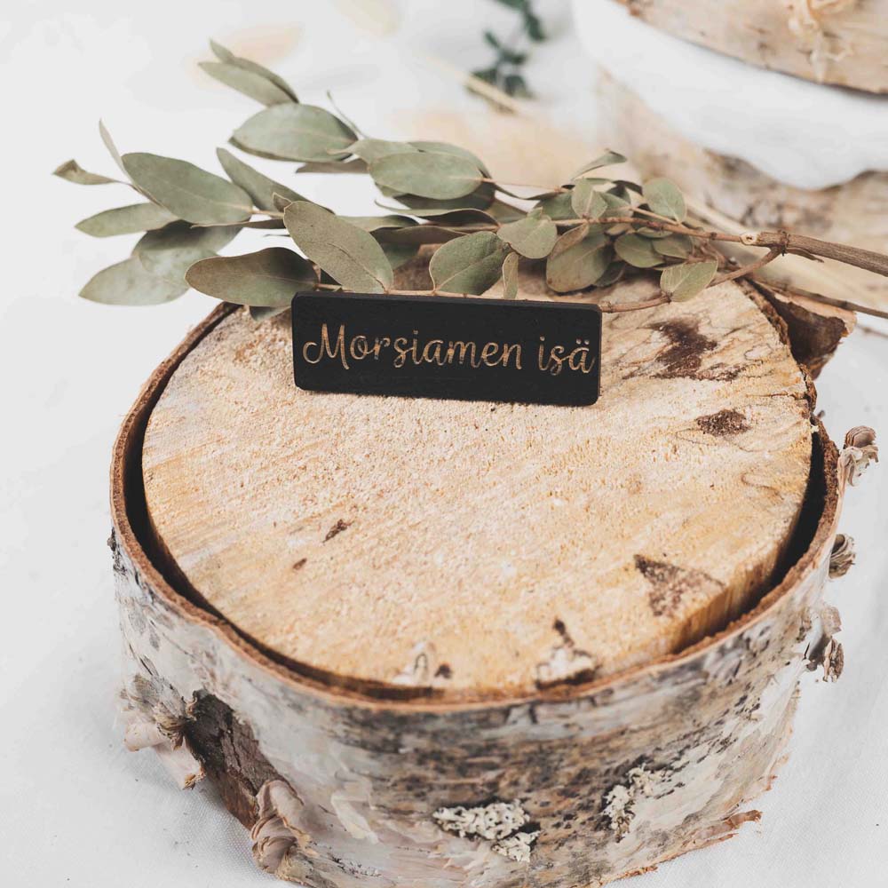Musta vanerinen paikkakyltti morsiamen isä tekstillä.