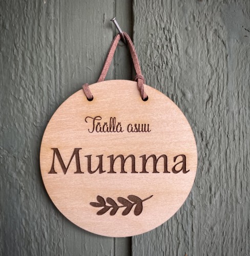 pyöreä kyltti, jossa teksti täällä asuu mumma