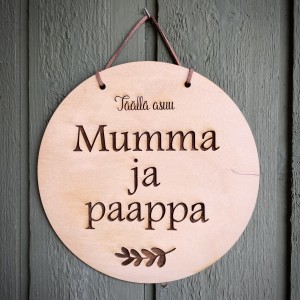 pyöreä kyltti, jossa teksti täällä asuu mumma ja paappa.