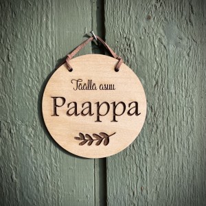 pyöreä kyltti, jossa teksti täällä asuu paappa