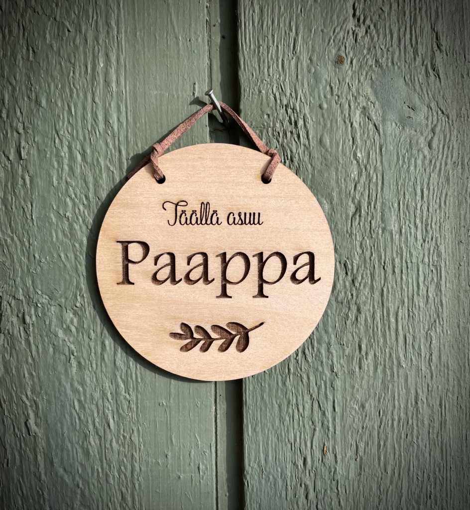 pyöreä kyltti, jossa teksti täällä asuu paappa