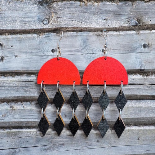 Korvakoru jossa punainen puoliympyrä ja mustat roikkuvat salmiakit