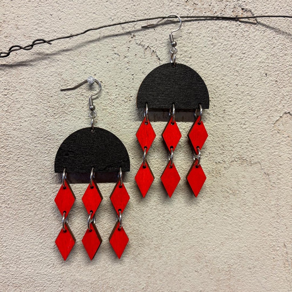 korvakoru, jossa mustassa puoliympyrässä roikkuu punaiset salmiakit