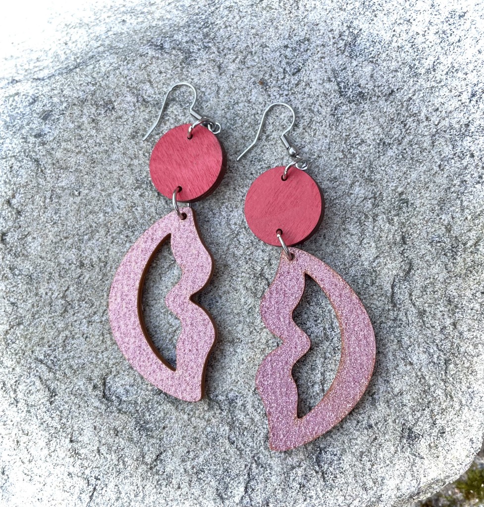 Korvakorut, joissa punainen pallo, josta roikkuu vaaleanpunaiset huulet.