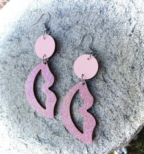 Korvakorut, jossa ylhäällä vaaleanpunainen pallo, josta roikkuu huultenmuotoinen pala.